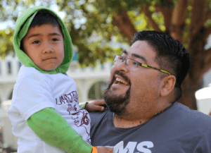 Photo of a young man being held by his father